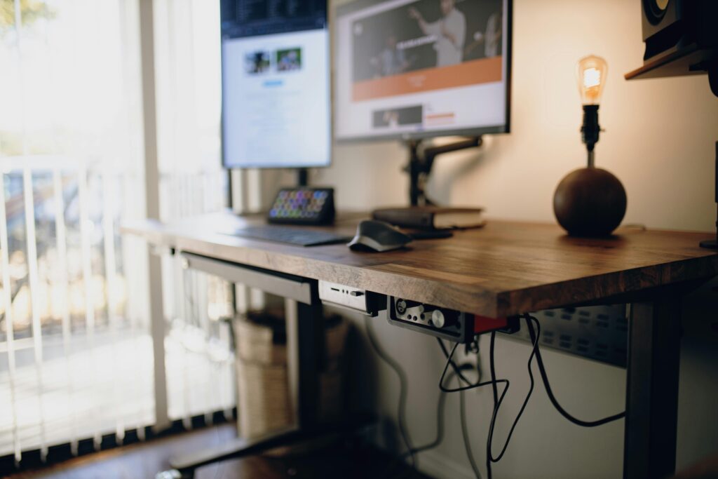 Clean and efficient home office setup with computer and standing desk.